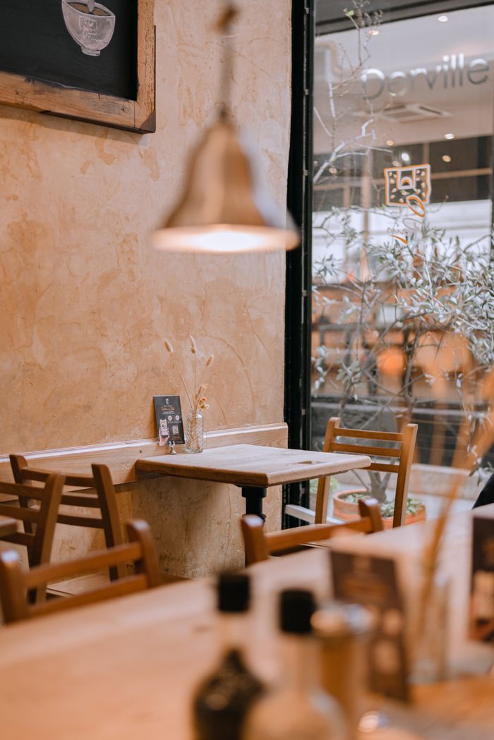 Warm and inviting interior of a Parisian cafe with wooden furniture and soft lighting, ideal setting for relaxation.