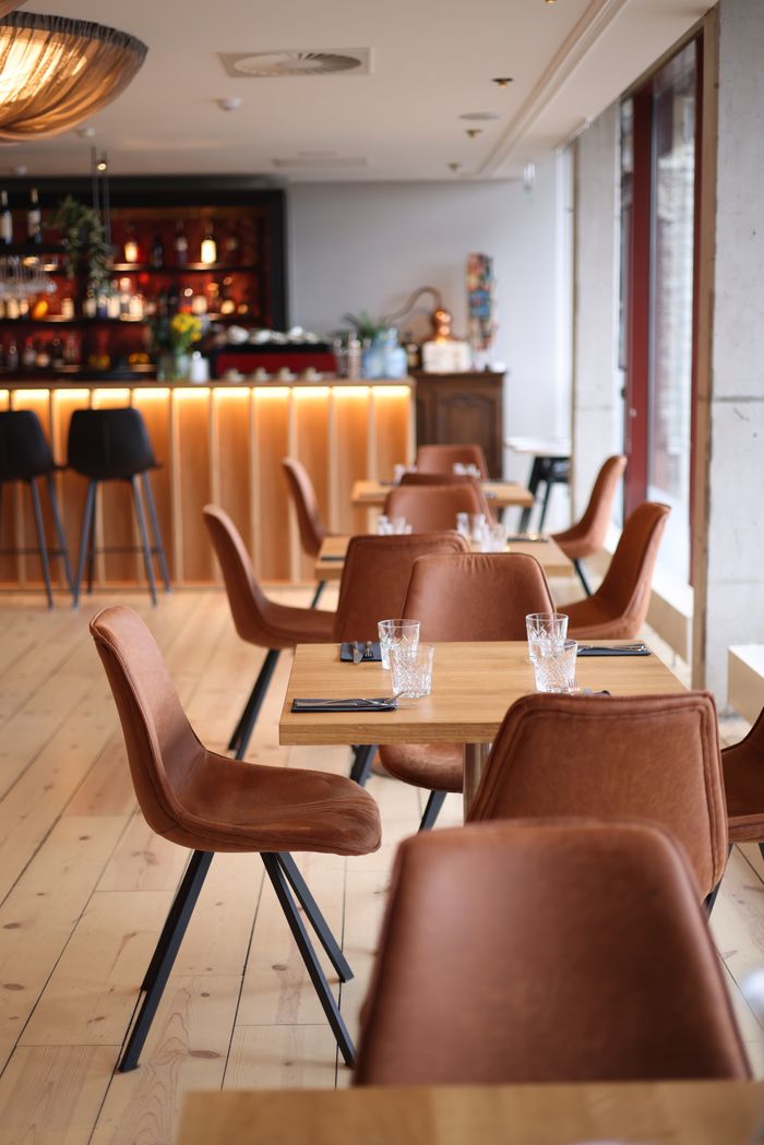 A stylish and contemporary cafe interior with wooden tables and seating in a cozy atmosphere.